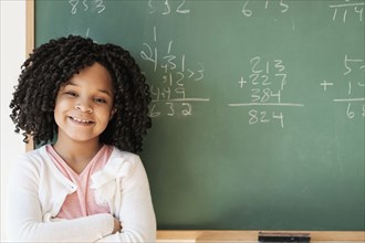 African American student smiling near chalkboard in classroom