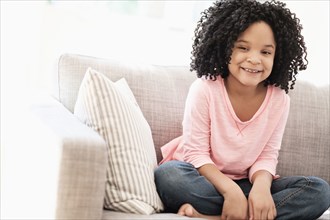 African American girl smiling on sofa