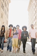 Multi-ethnic friends walking down urban sidewalk