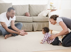 African couple with baby in living room