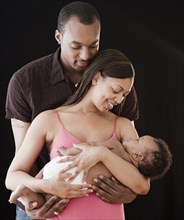 African couple holding sleeping baby