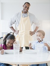 African American father preparing dinner for children