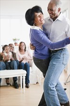 African American man dancing with wife in living room