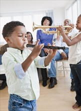 African American family watching children play instruments