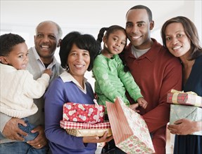 African American family holding Christmas gifts