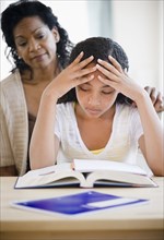 Mother comforting frustrated daughter doing homework