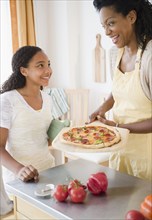 Mother and daughter preparing pizza for dinner
