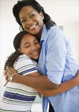 Mother hugging daughter