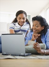 Mother and daughter using credit card online