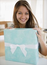 Smiling Indian woman holding birthday gift