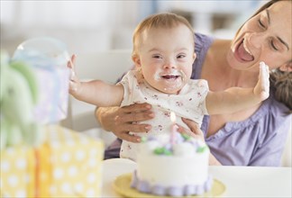 Caucasian mother and baby girl with Down Syndrome celebrating birthday