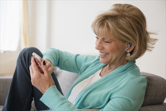 Older Caucasian woman listening to music on cell phone