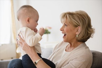 Caucasian grandmother making a face at baby granddaughter