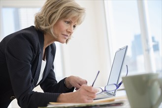 Caucasian businesswoman using laptop