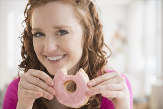 Caucasian woman eating donut