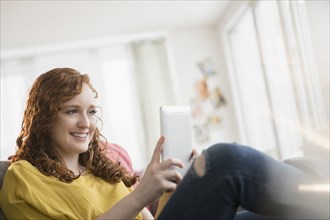 Smiling Caucasian woman using digital tablet