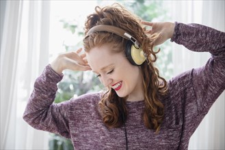 Caucasian woman listening to headphones and dancing