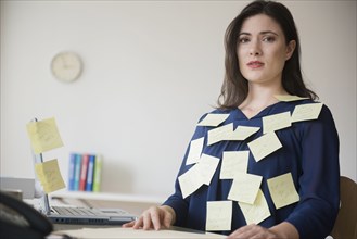 Blouse of stressed Caucasian businesswoman covered with adhesive notes