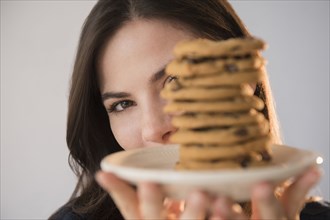 Caucasian woman showing pile of cookies on plate
