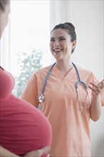 Caucasian nurse consulting with expectant mother