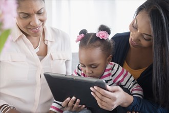 Black multi-generation family using digital tablet