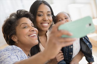 Black multi-generation family talking selfie