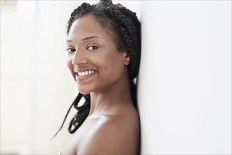 Smiling Black woman leaning on wall
