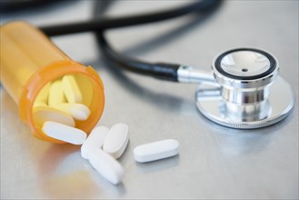 Stethoscope and pills in prescription bottle