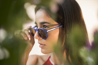 Indian woman peering over sunglasses