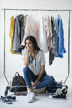 Indian woman sitting on clothing rack
