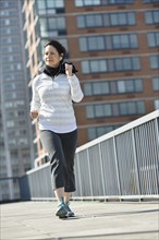 Hispanic woman running in city