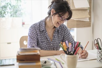 Hispanic woman sketching in home office