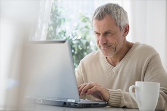 Older Caucasian man using laptop