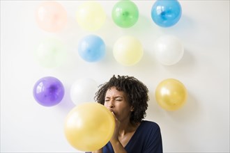 Black woman inflating balloon