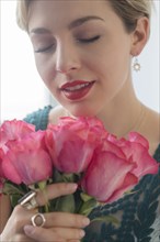 Caucasian woman smelling pink roses