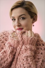Caucasian woman snuggling in pink sweater