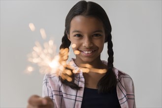 Mixed Race girl holding sparkler