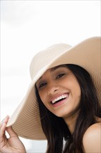 Smiling Mixed Race woman wearing sun hat