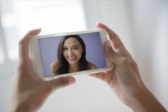 Mixed Race woman video chatting on cell phone
