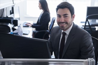 Portrait of smiling businessman using computer in office