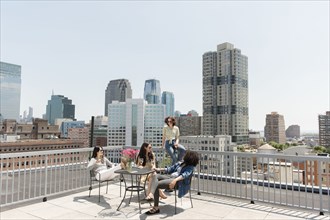 Women drinking wine on urban rooftop