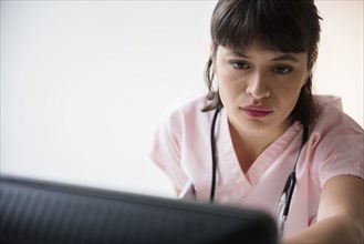 Hispanic nurse using computer
