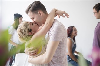 Couple hugging and kissing at party