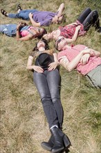 Friends relaxing in sunny grass field