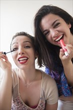 Smiling Caucasian women applying makeup