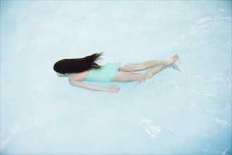 Caucasian girl swimming in swimming pool