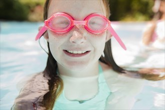 Caucasian girl in swimming pool wearing goggles