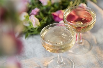 Glasses of champagne near flowers