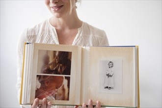 Caucasian woman showing photo album