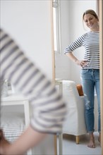 Reflection of standing Caucasian woman in mirror